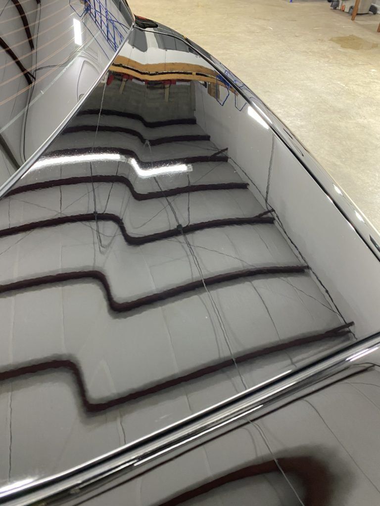 The roof of a car is reflected in a mirror.