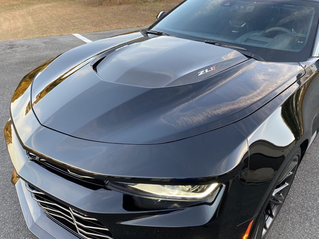A black chevrolet camaro is parked in a parking lot