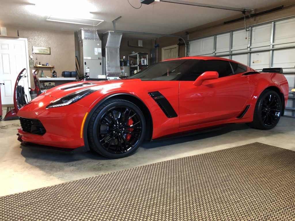 A red sports car is parked in a garage.