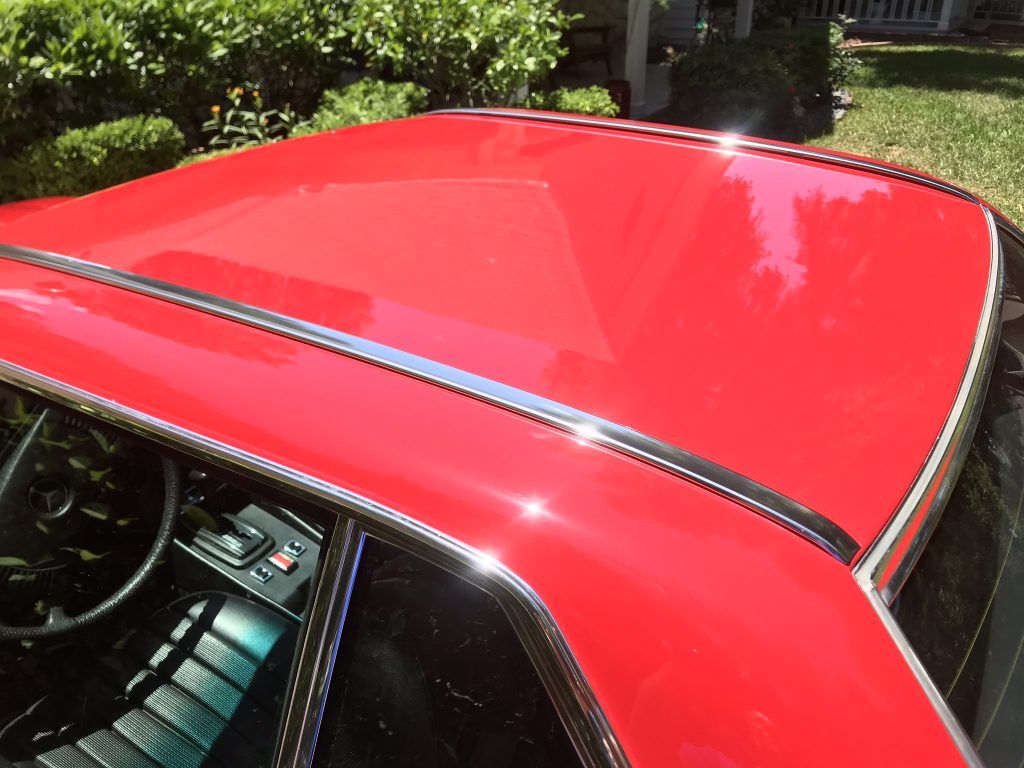 The roof of a red car is shiny and shiny