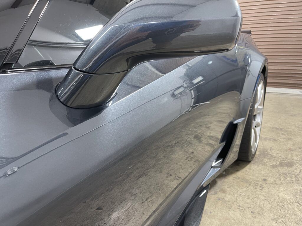 A close up of a car 's side mirror in a garage.