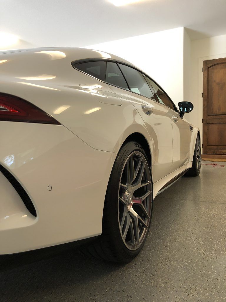 A white sports car is parked in a garage