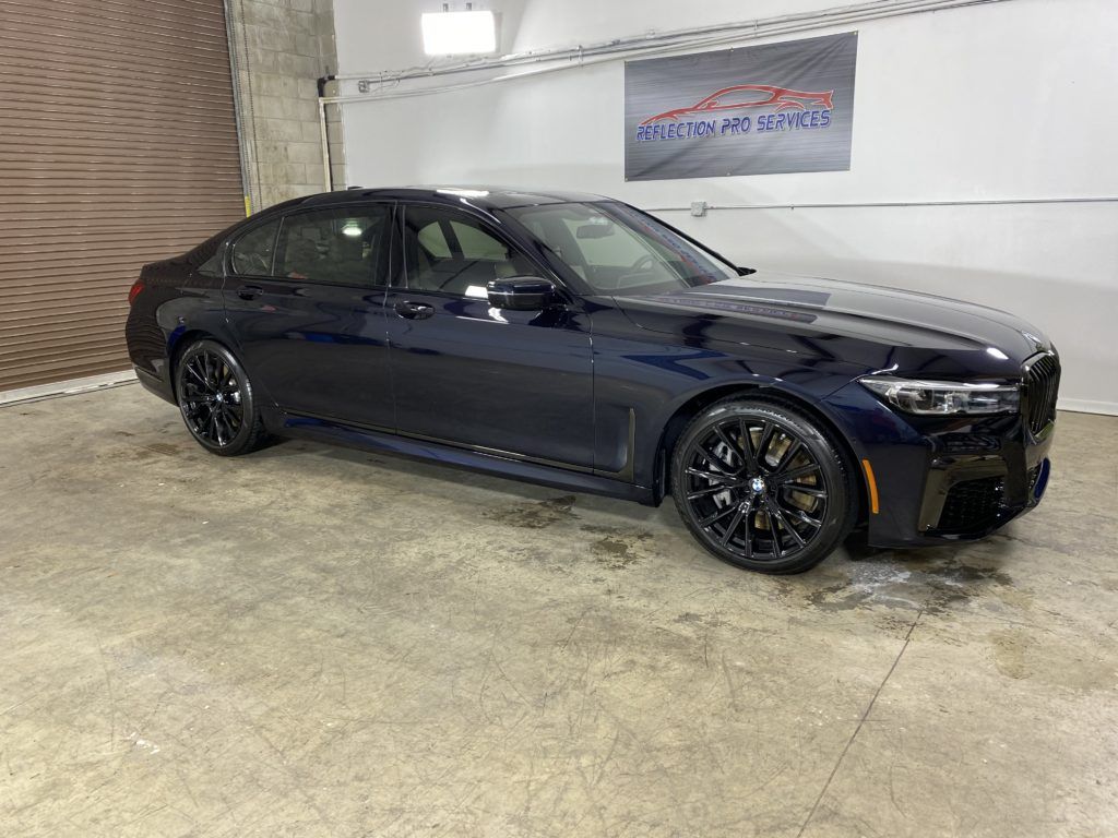 A black bmw 3 series is parked in a garage.