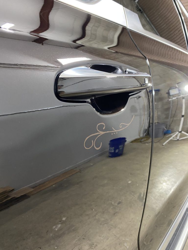A close up of a car door handle in a garage.