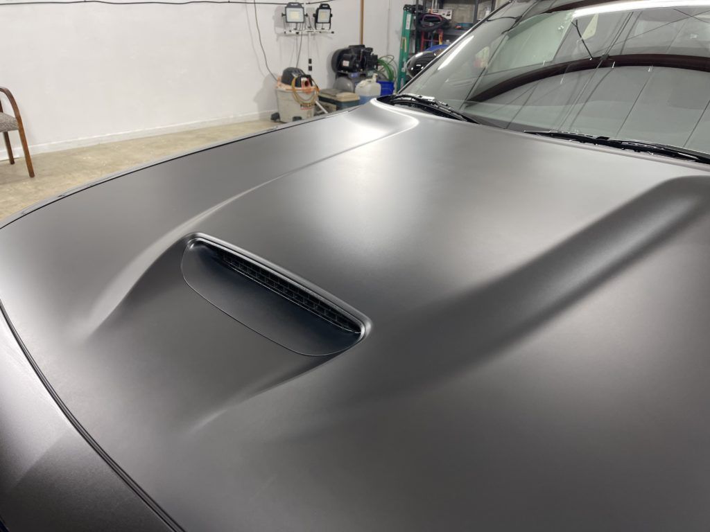 A close up of the hood of a car in a garage.