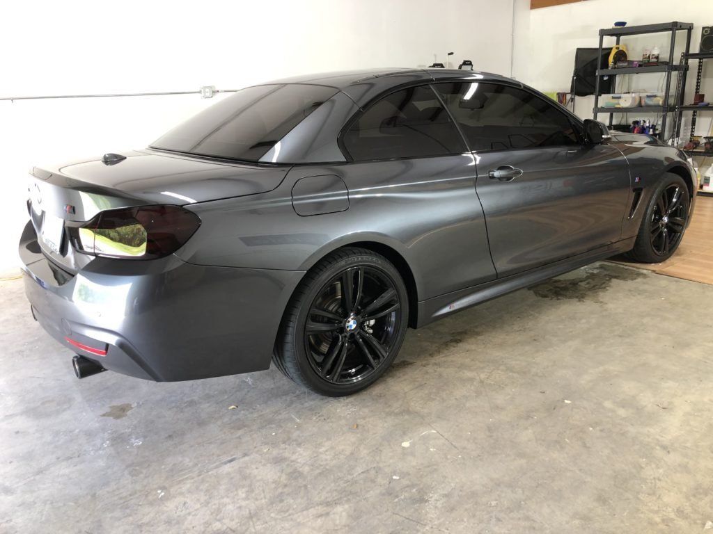 A gray bmw is parked in a garage.