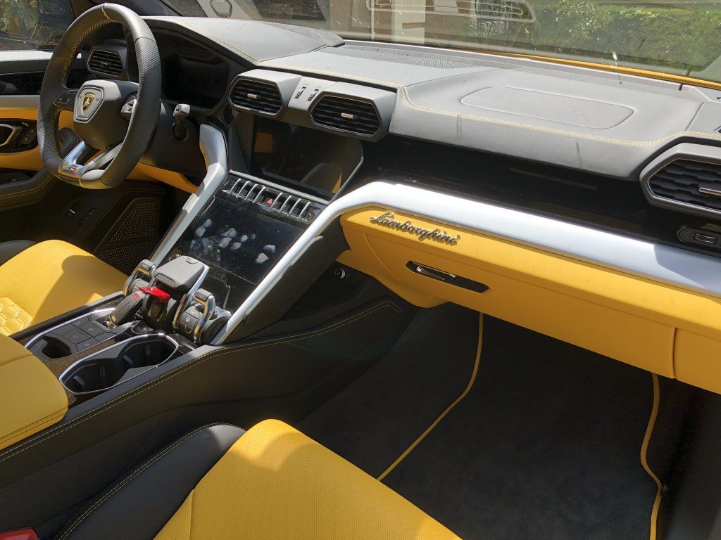 The interior of a lamborghini urus with yellow seats