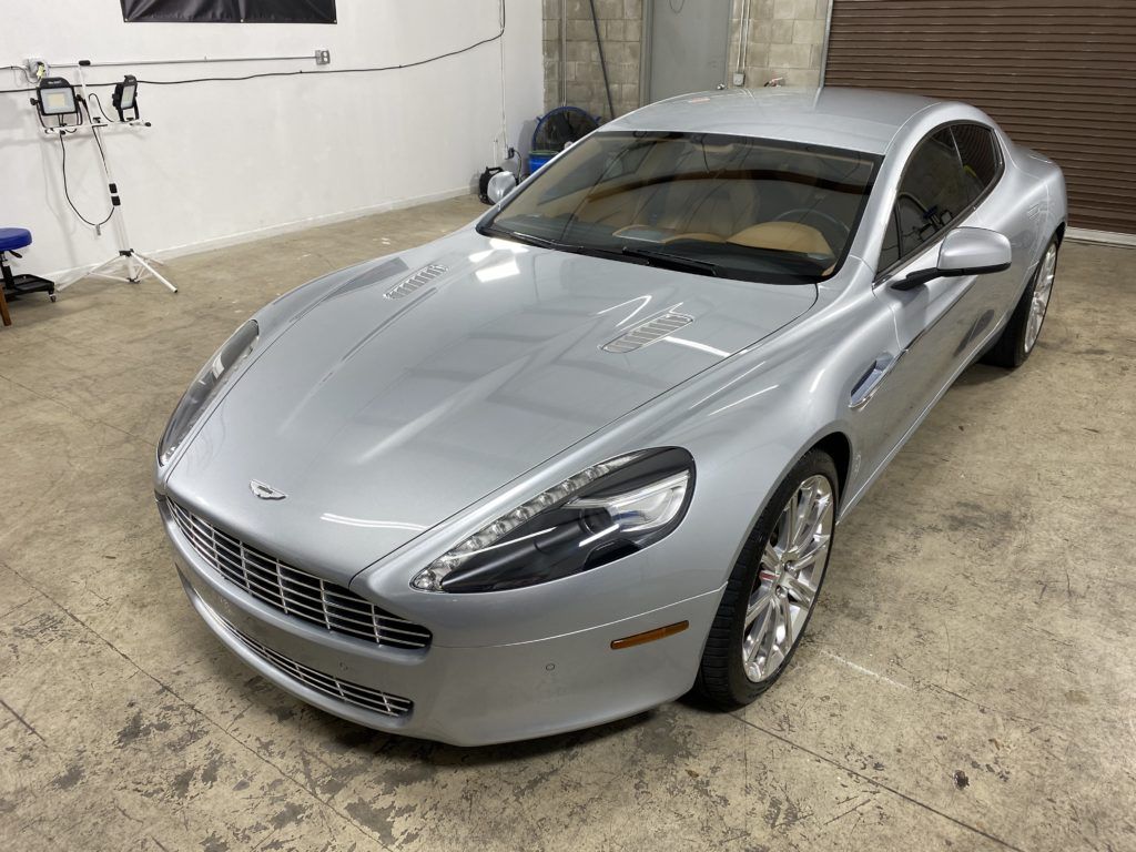 A silver sports car is parked in a garage.