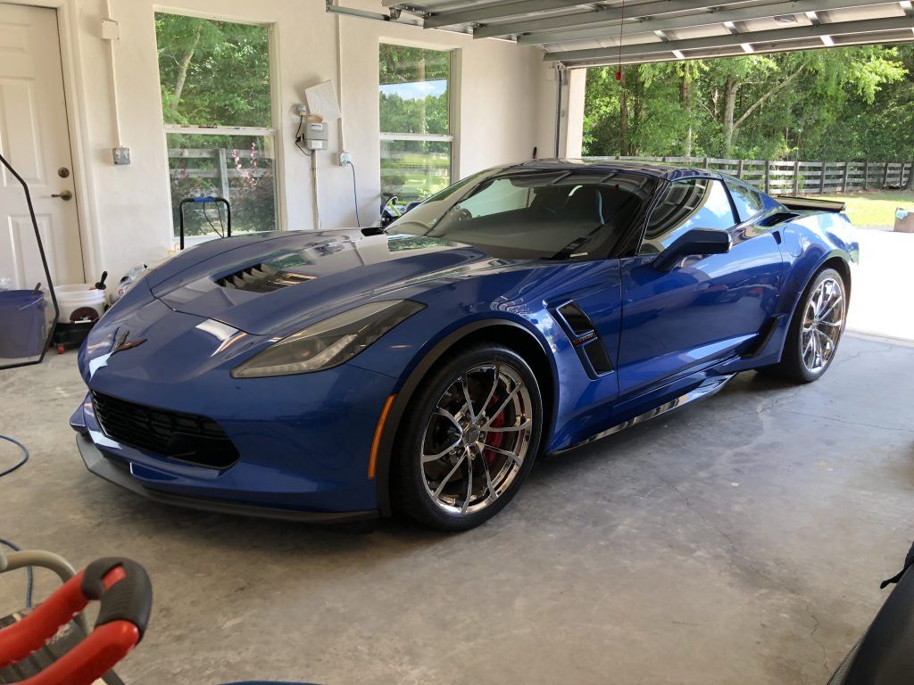 A blue corvette is parked in a garage.