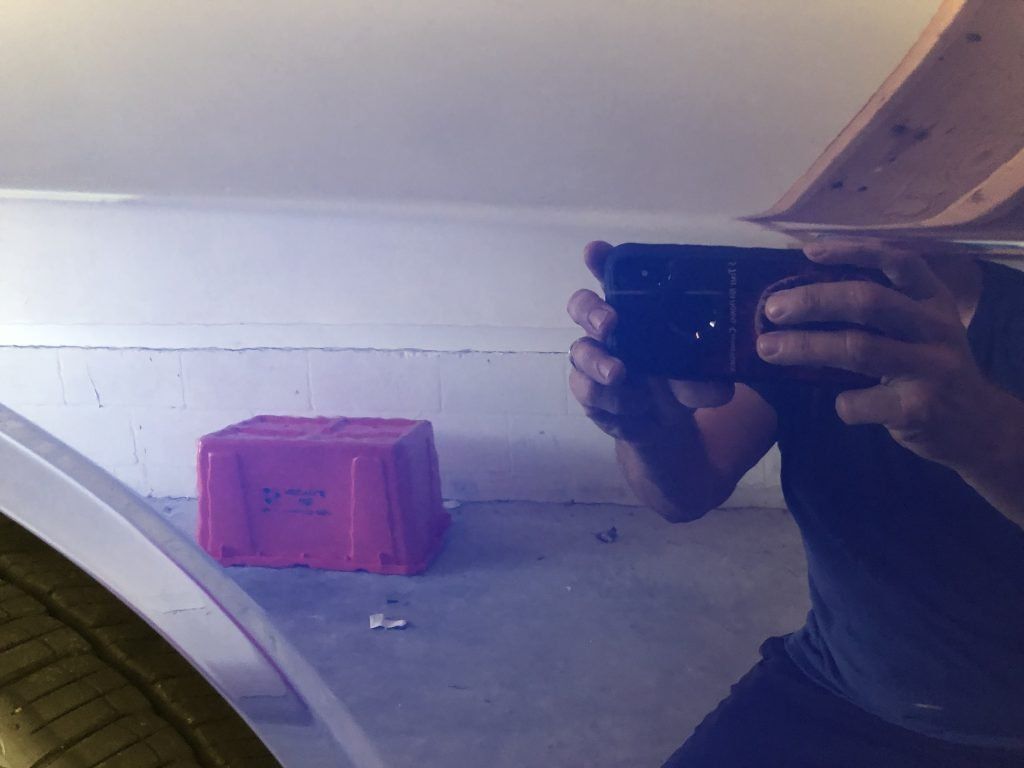 A person is taking a picture of their reflection in a mirror