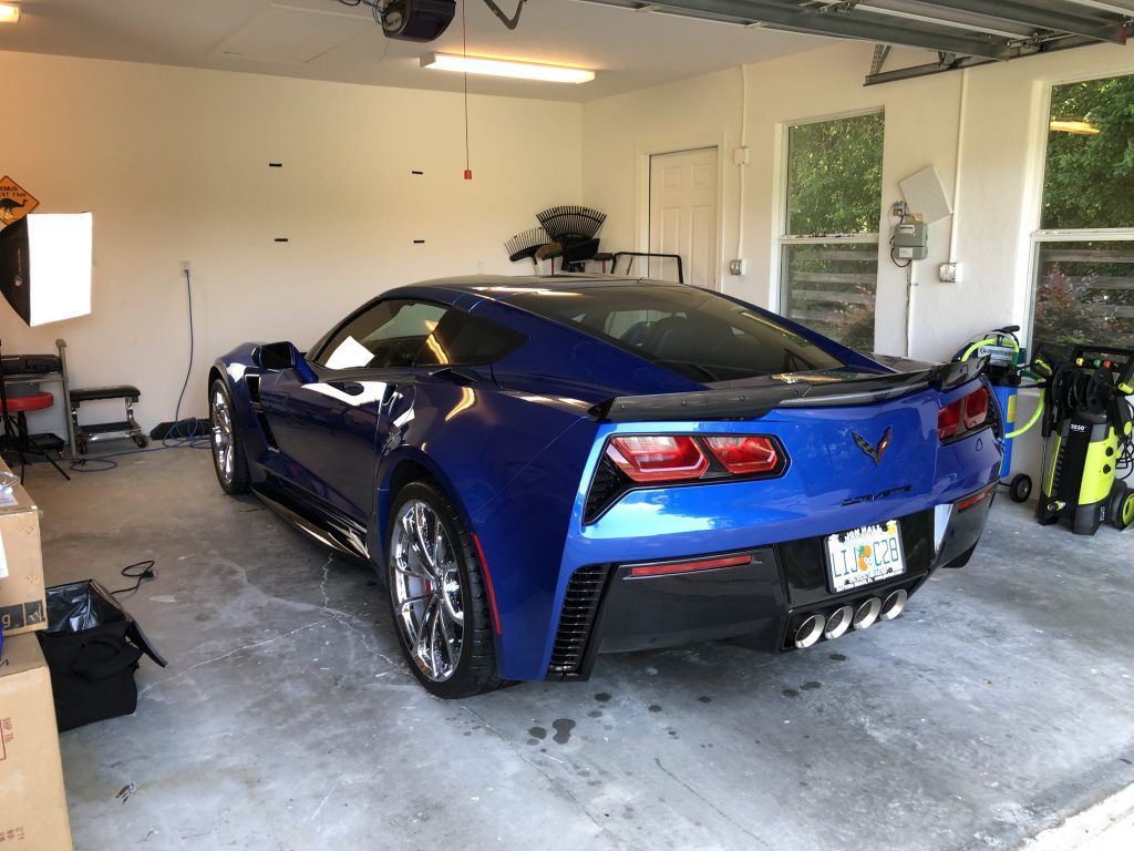 A blue sports car is parked in a garage.