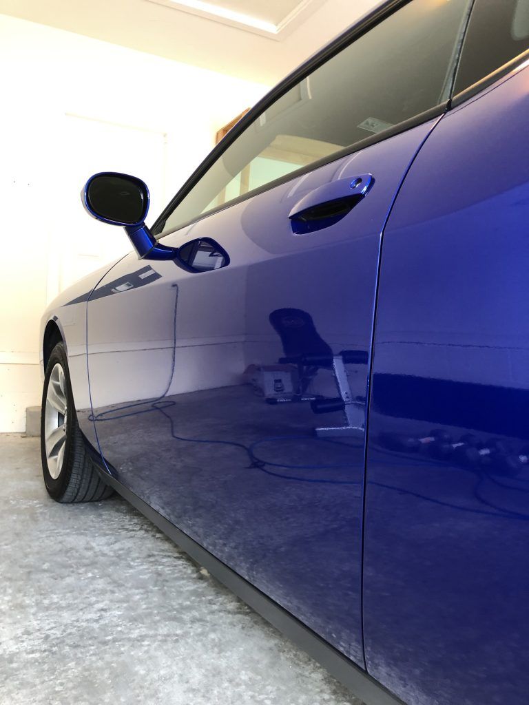 A blue car is parked in a garage.