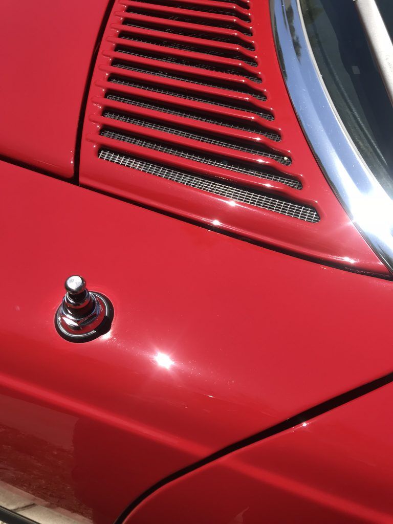 A close up of a red car with a chrome trim