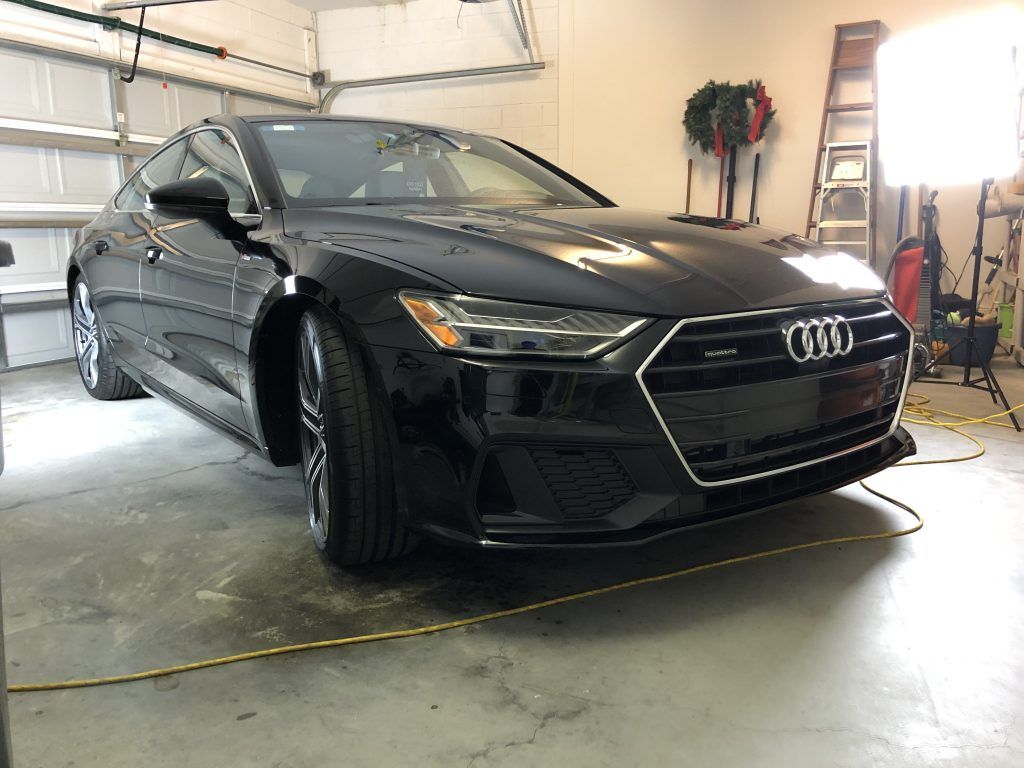 A black audi a7 is parked in a garage.