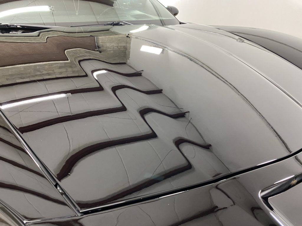 A close up of the hood of a car in a garage.