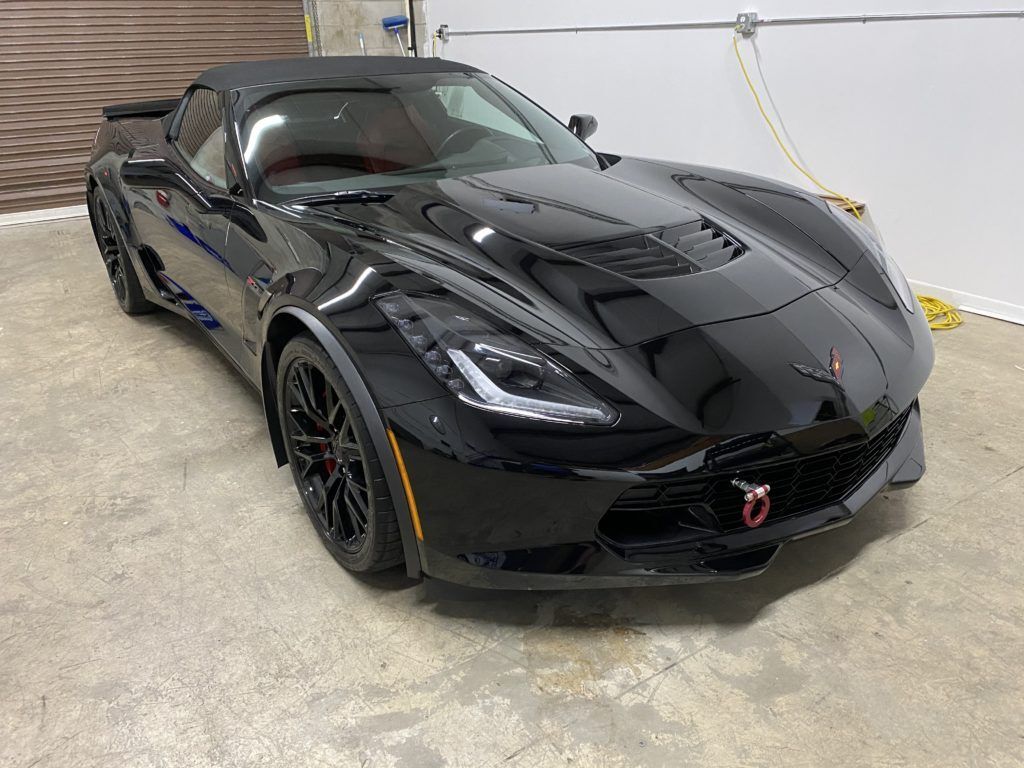A black corvette zr1 is parked in a garage.