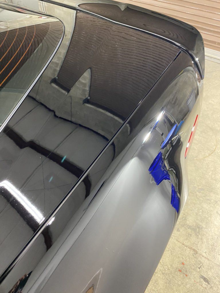 A close up of the rear end of a black car.