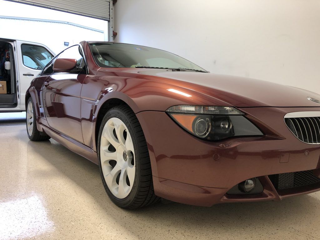 A red car is parked in a garage with the door open
