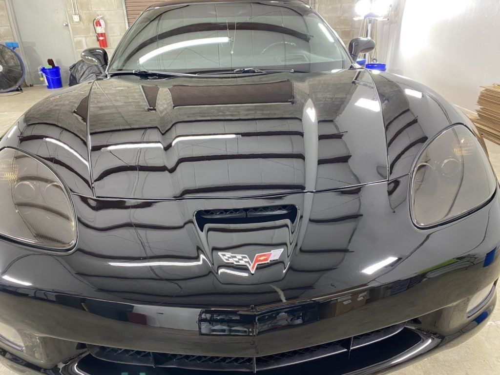A black sports car is parked in a garage.