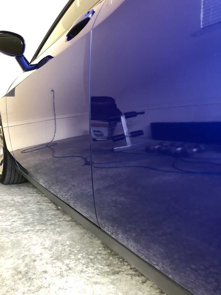 A blue car is parked in a garage.