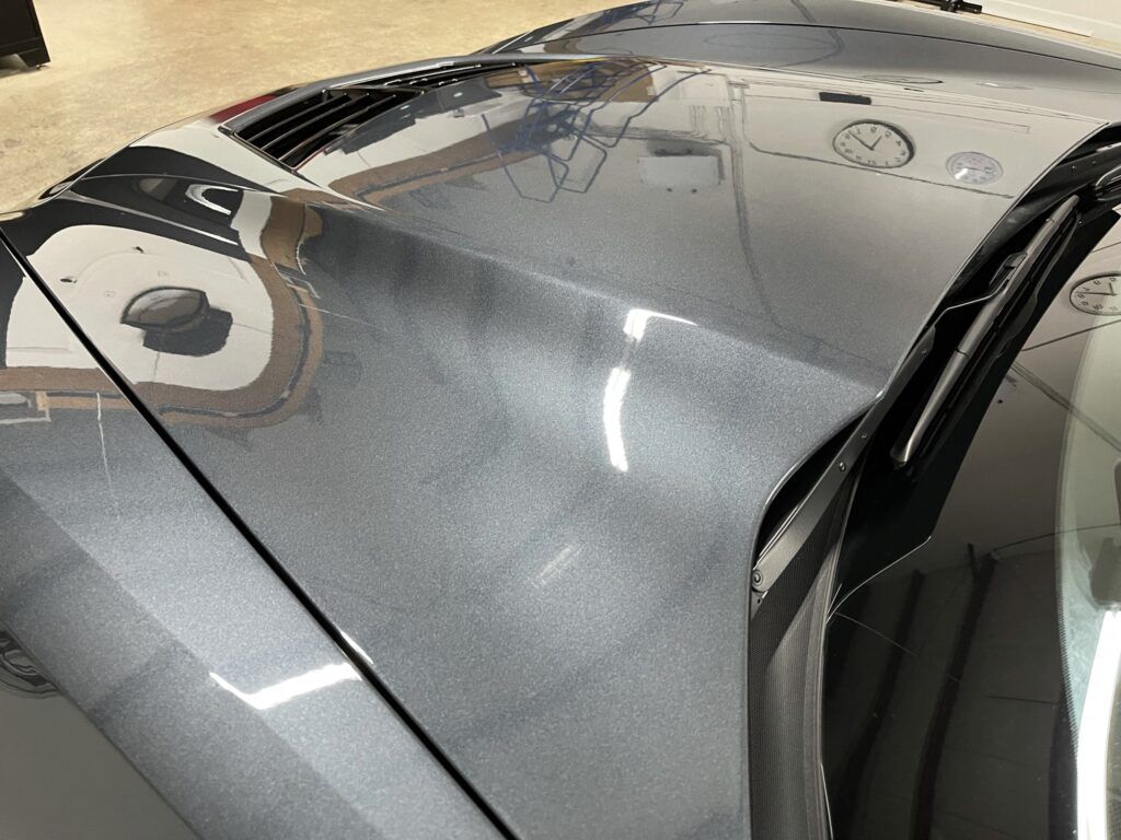A close up of the hood of a gray sports car.