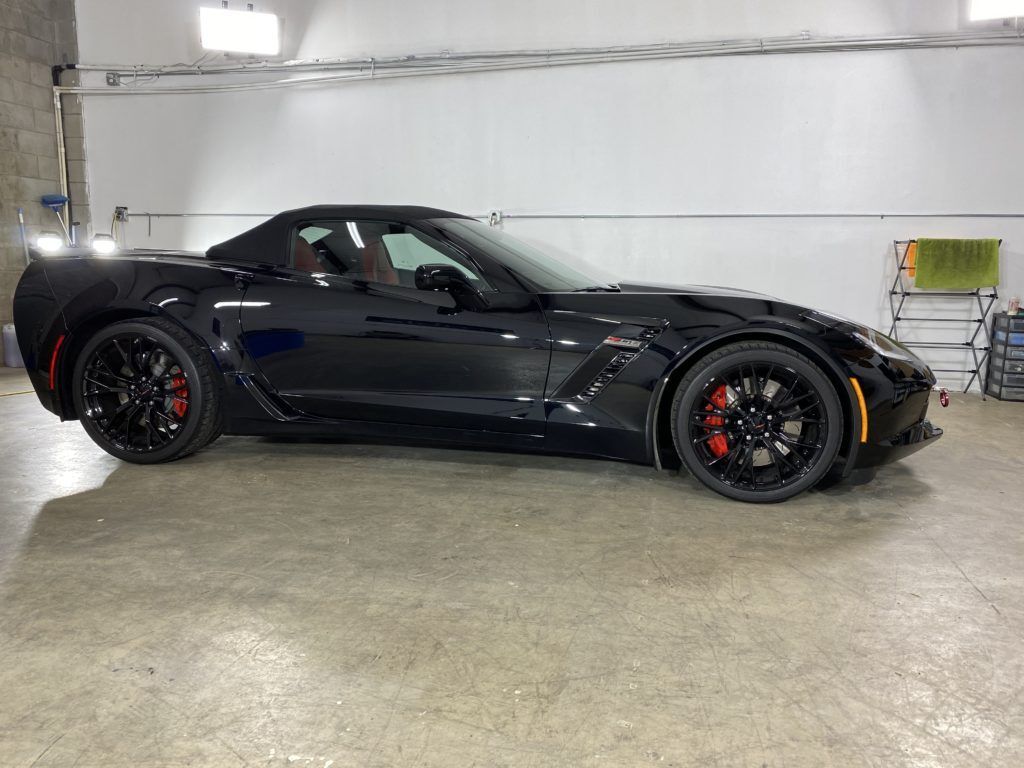 A black corvette zr1 is parked in a garage.