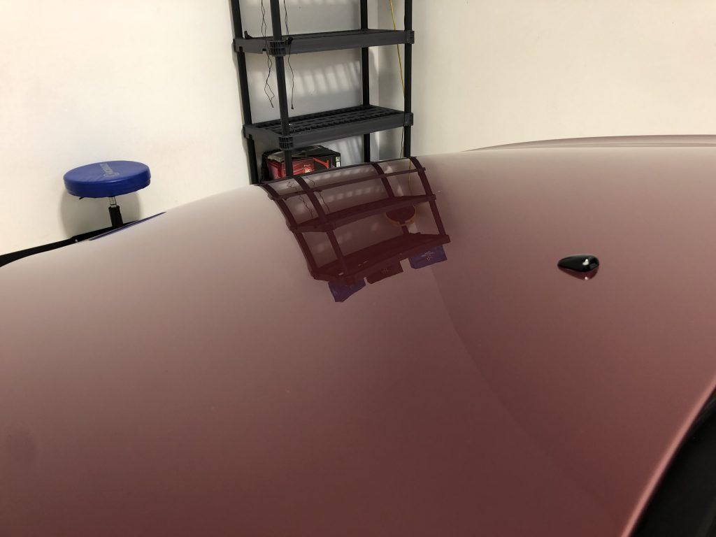 A bottle of lotion is sitting on a wall next to a shelf.