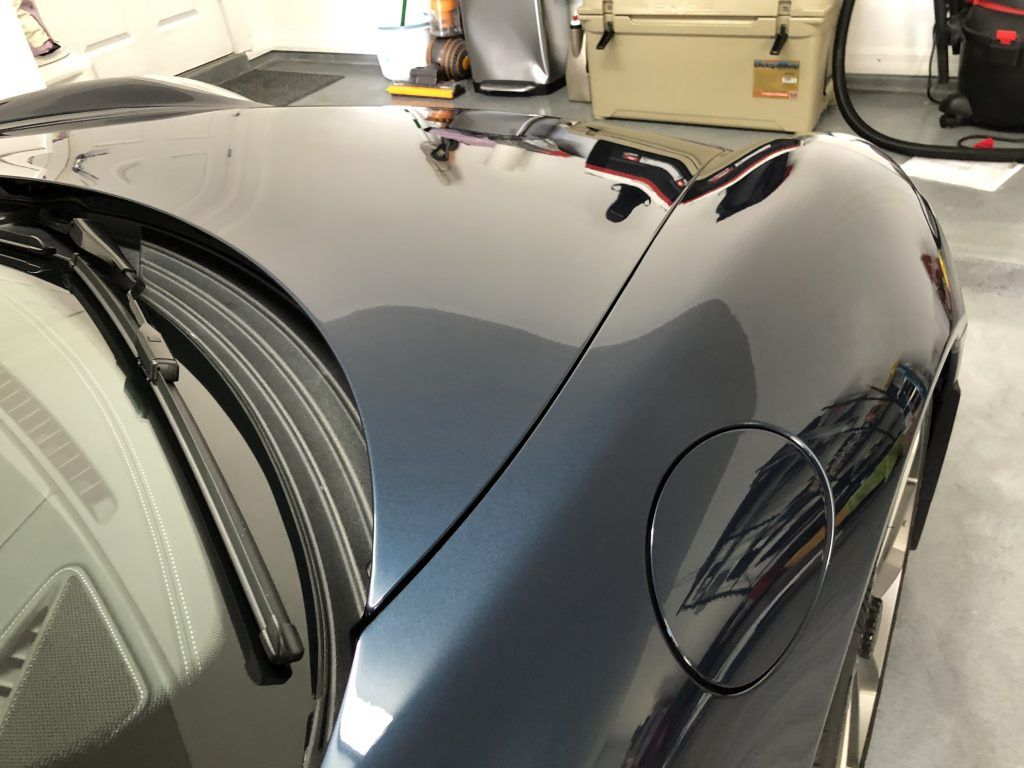 A close up of a car 's hood in a garage.
