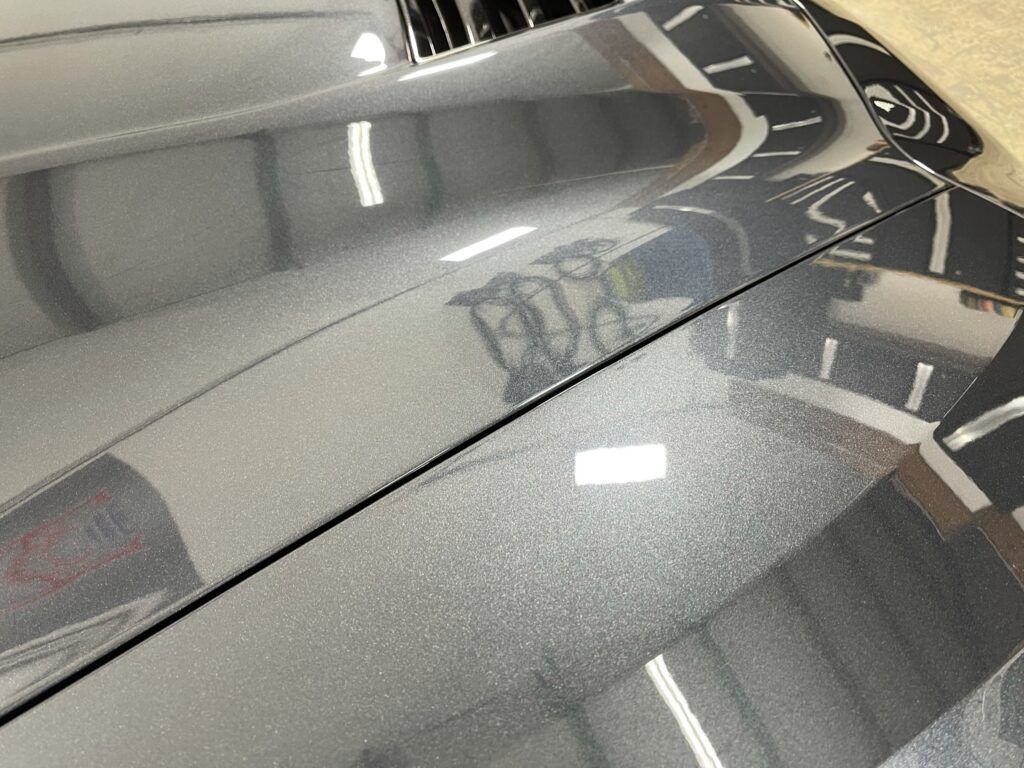 A close up of the hood of a car in a garage.