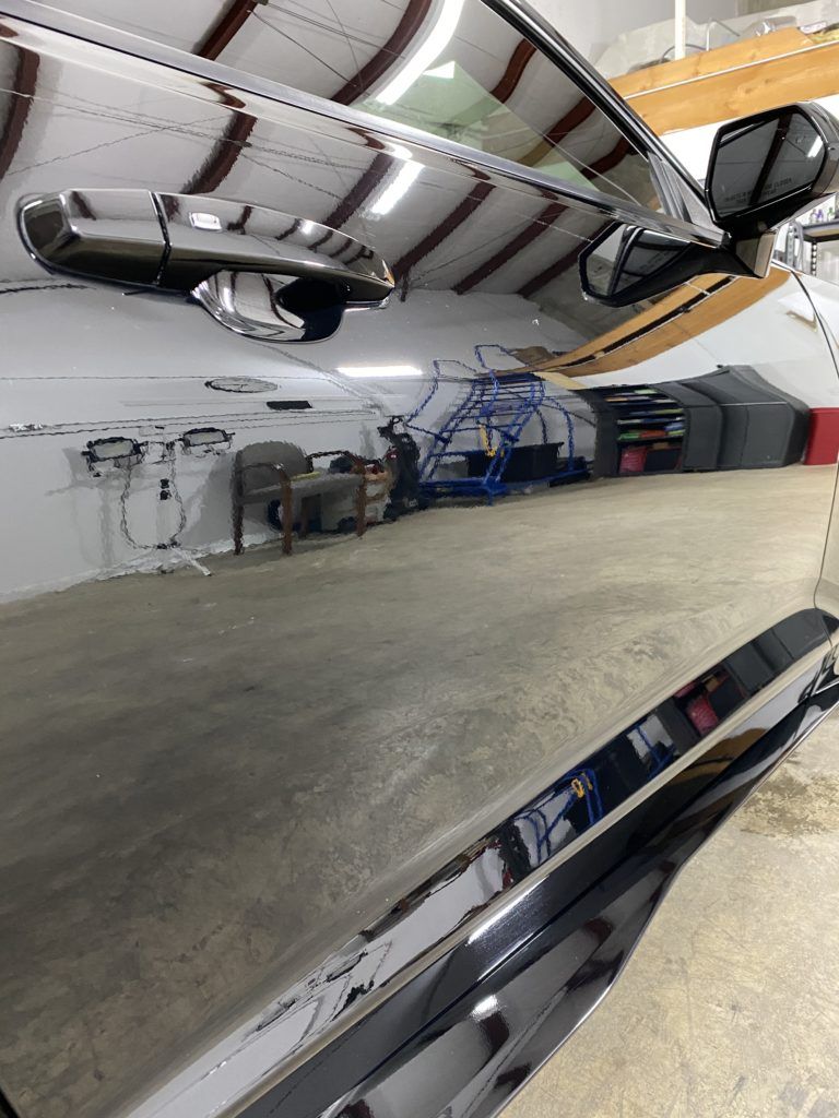 A black car is parked in a garage.