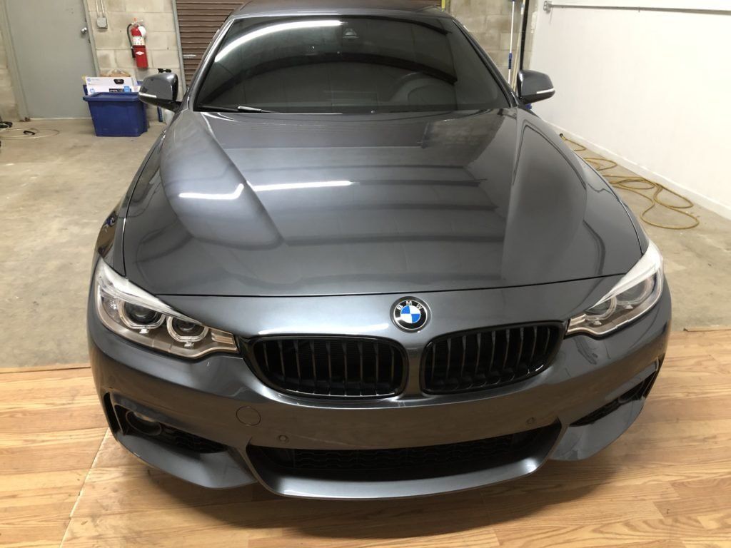 A gray bmw is parked in a garage.