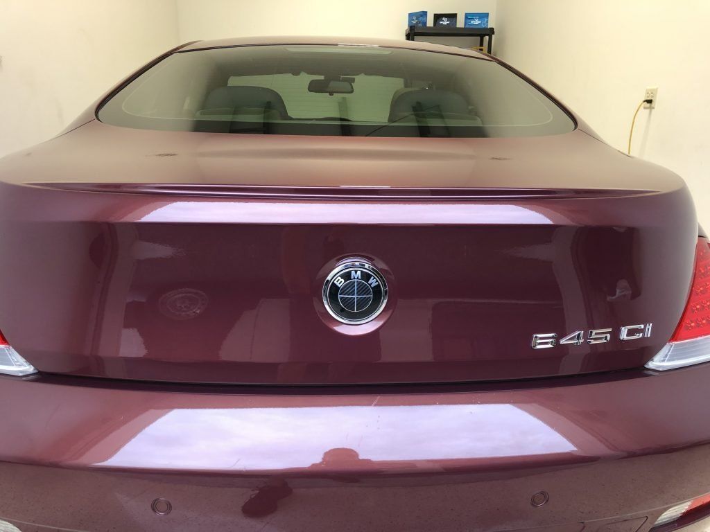 A burgundy bmw s450 is parked in a garage