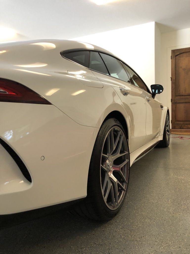 A white sports car is parked in a garage