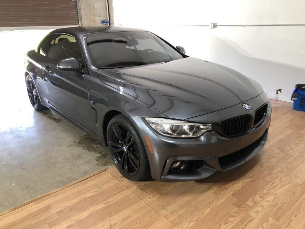 A bmw 4 series convertible is parked in a garage.