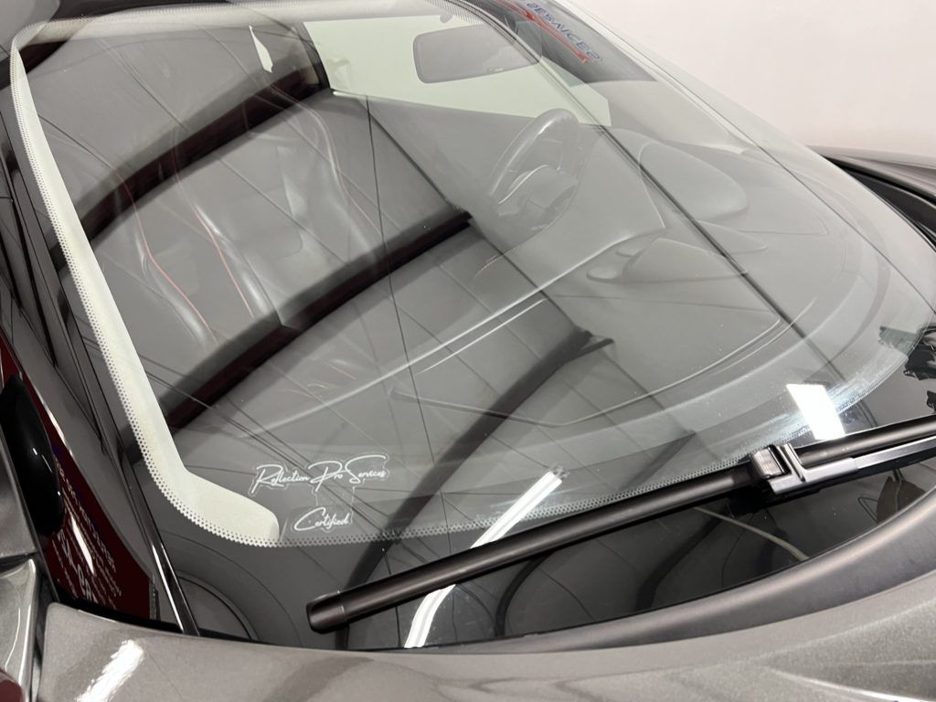 A close up of a car windshield with a wiper on it