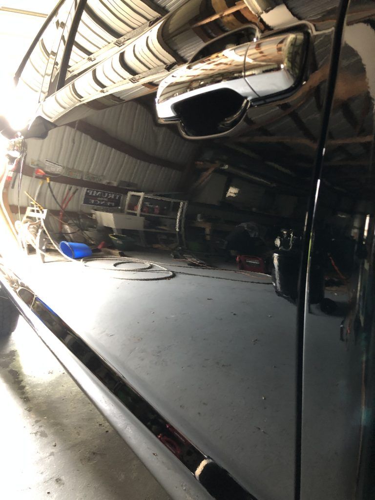 A black truck is parked in a garage.