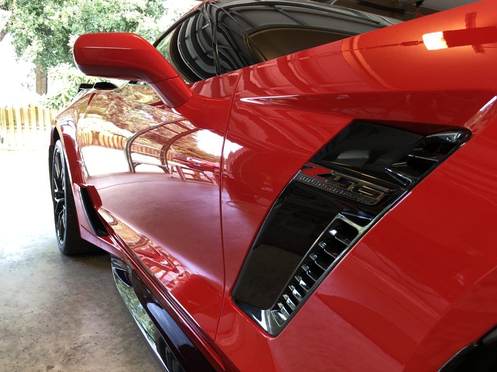 A red sports car is parked in a garage