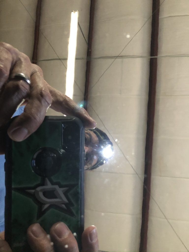 A person is taking a picture of their reflection in a mirror.