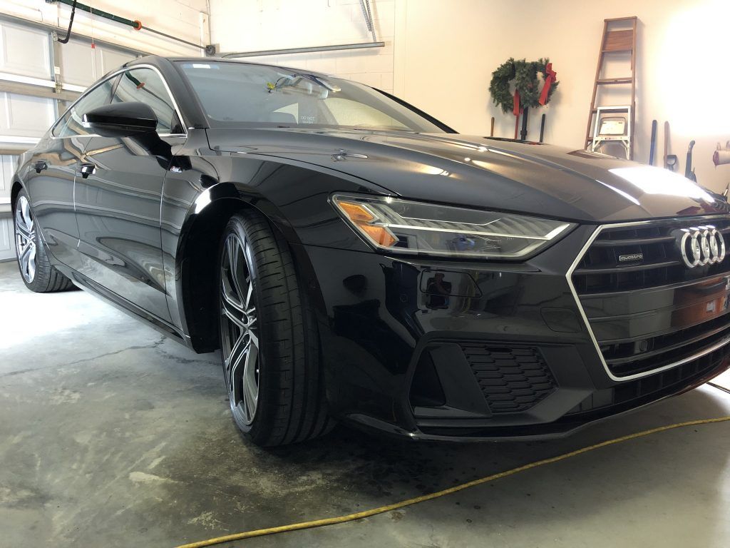 A black audi a7 coupe is parked in a garage.