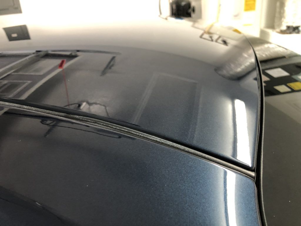 A close up of the hood of a car in a garage