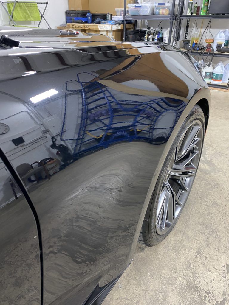 A black car is parked in a garage.