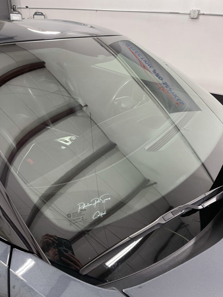 A close up of a car windshield in a garage.