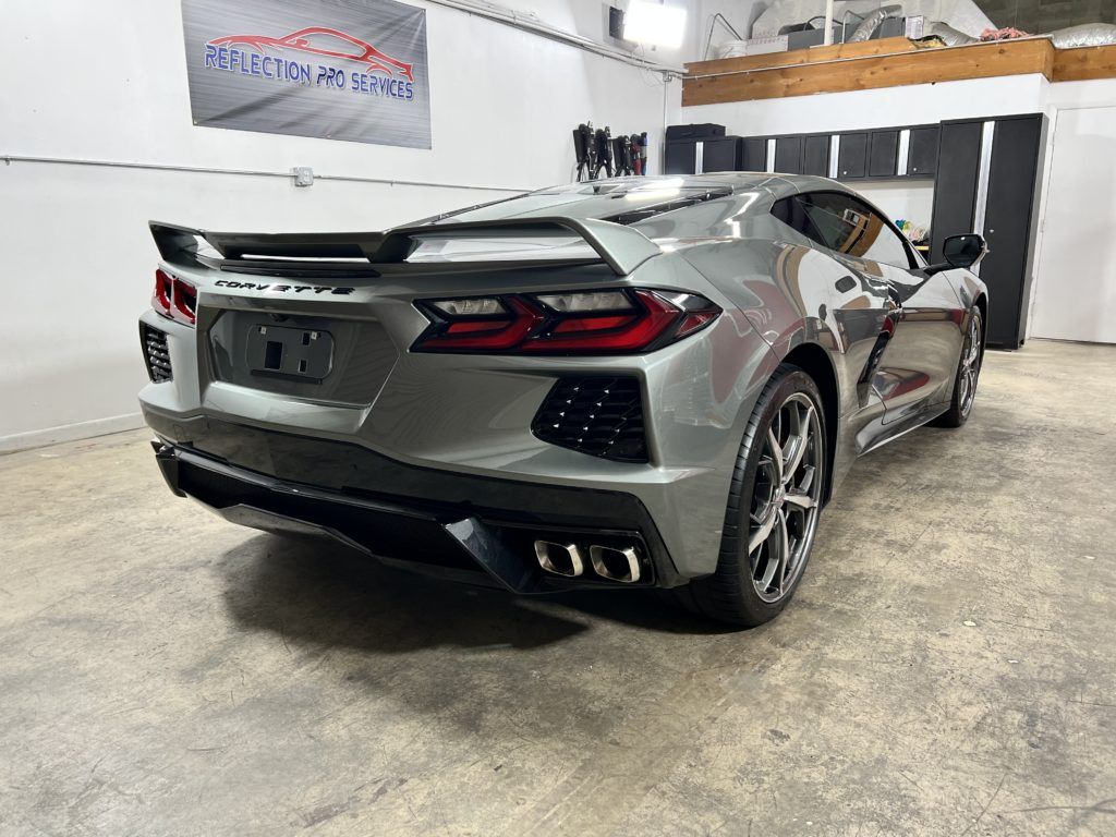 A silver sports car is parked in a garage.