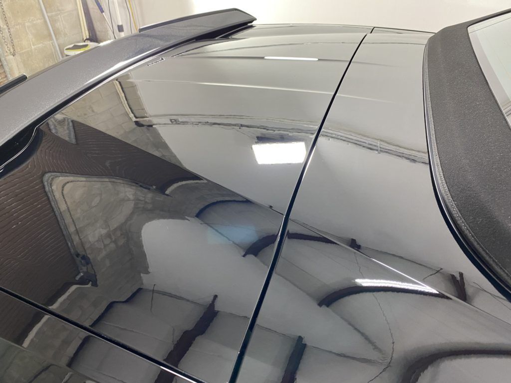 A car with a convertible top is parked in a garage.