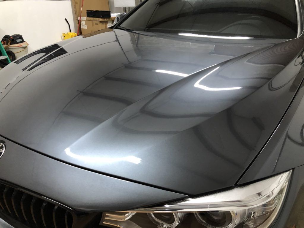 A close up of a car 's hood in a garage.