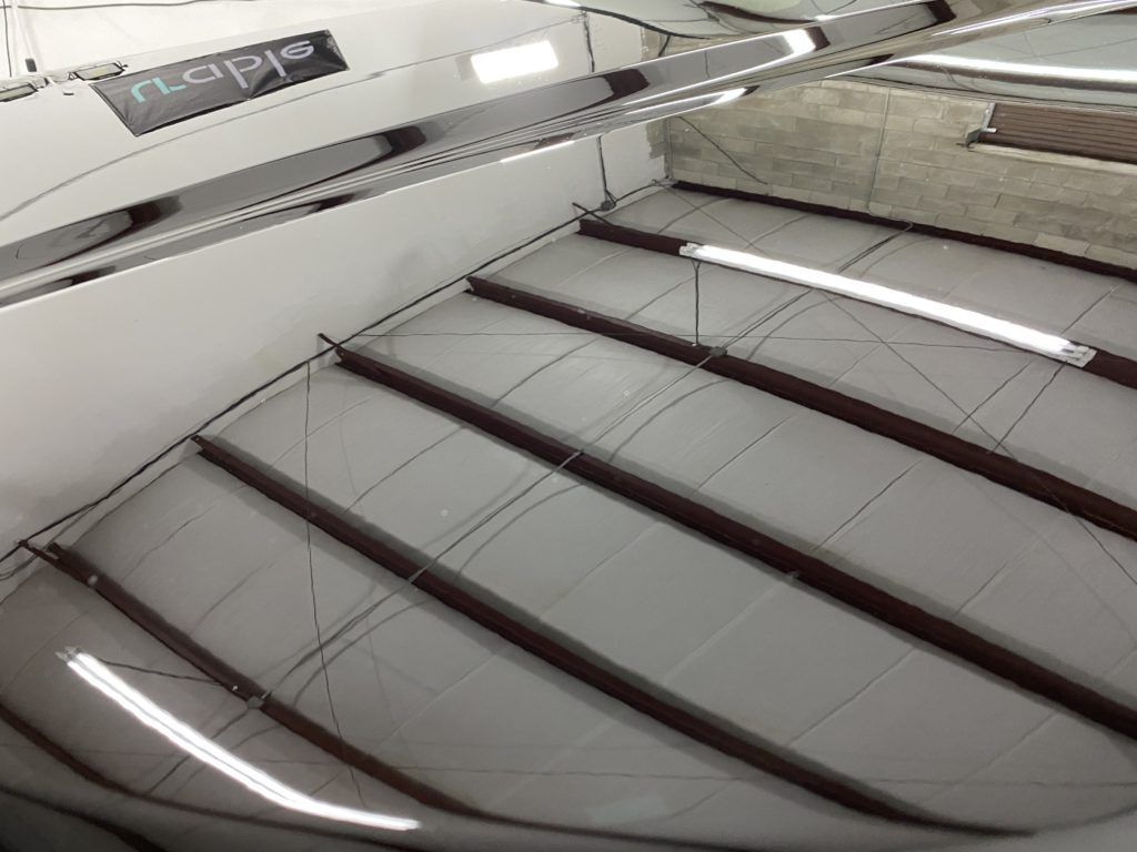 A close up of a car 's hood in a garage.