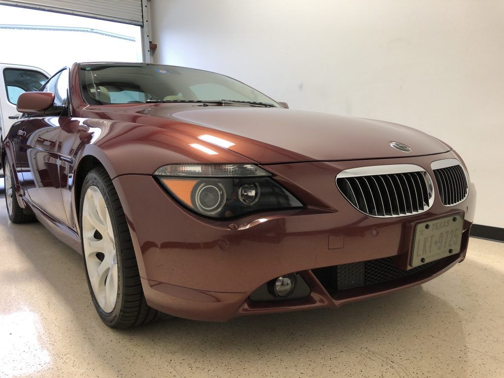 A red bmw is parked in a garage.