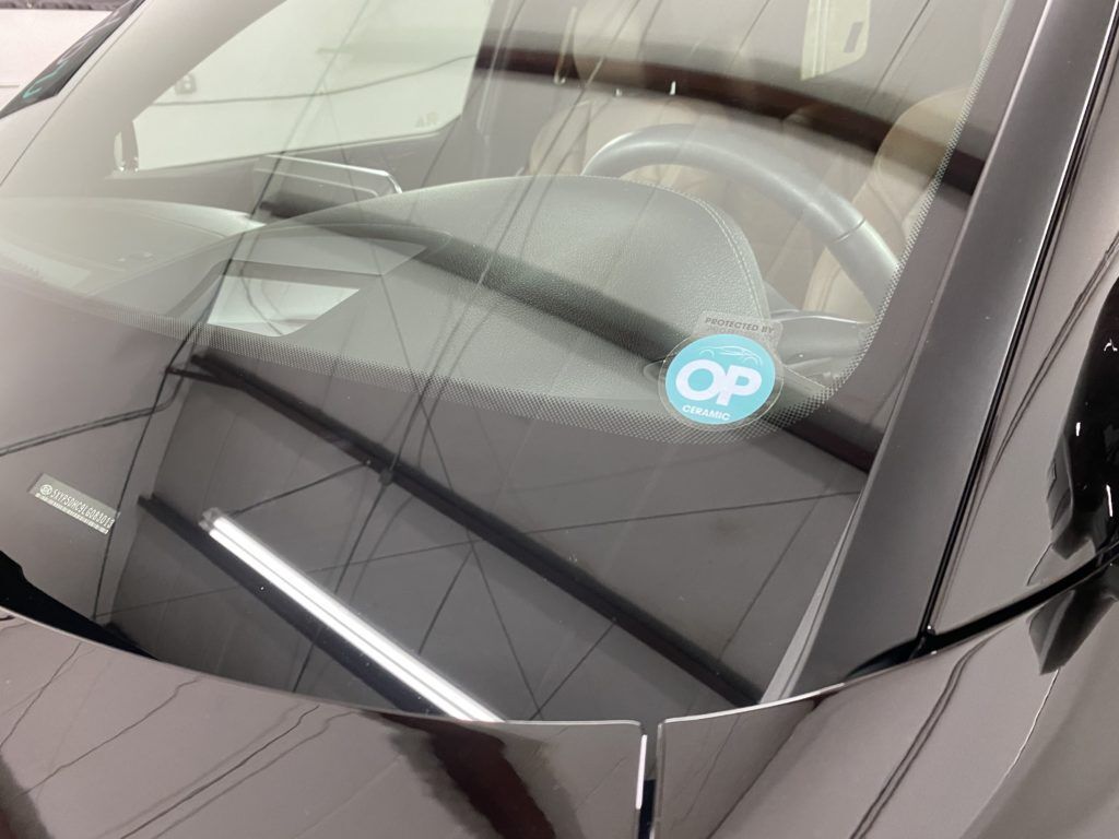 A close up of a car windshield with a sticker on it.