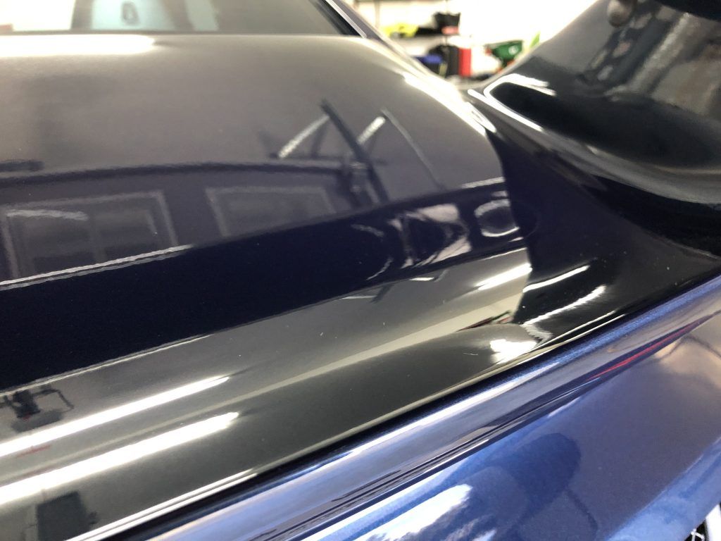 A close up of a car 's hood and side mirror