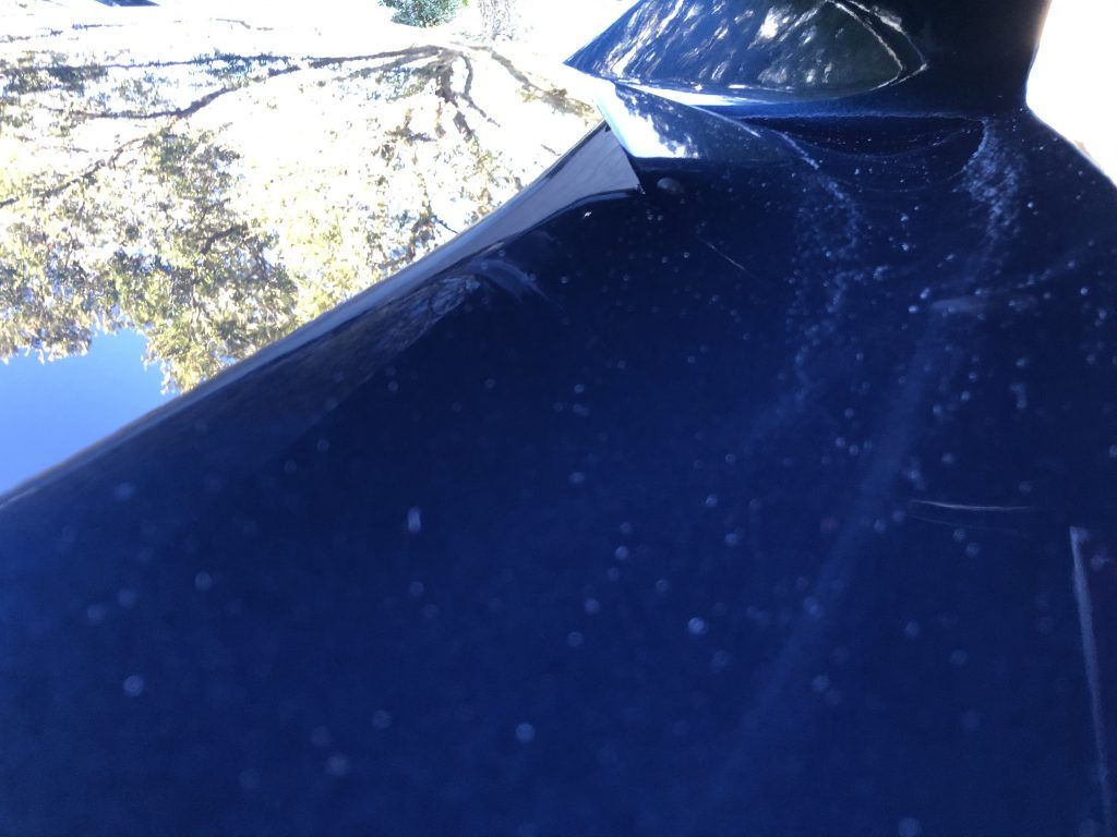 A close up of a blue car with a antenna on top of it